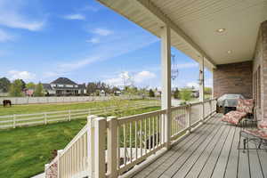 Covered deck featuring view of the separetly fenced backyard and fenced horse pasture