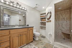 Spacious 3rd Bathroom with built in features, vanity, a marble finish shower, and recessed lighting