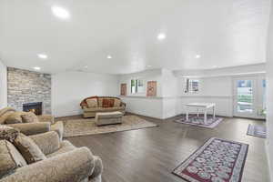 Open concept living/dining area featuring gorgeous flooring, a stone fireplace, and recessed lighting