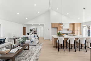 Living area with light wood-style flooring and recessed lighting