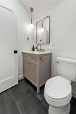 Bathroom with vanity and dark tile patterned floors