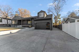 View of front facade featuring driveway, a garage, and a porch