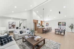 Living room with light wood finished floors, recessed lighting, and lofted ceiling