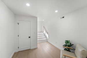 Staircase featuring wood finished floors, recessed lighting, and a textured ceiling
