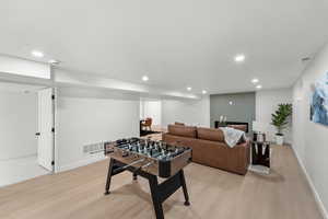 Rec room with light wood-type flooring and recessed lighting