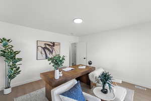 Office area with baseboards and light wood finished floors