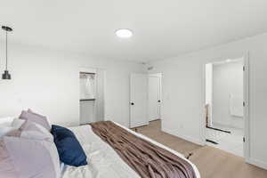 Bedroom with ensuite bathroom and light wood finished floors