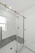 Full bath with a stall shower and light tile patterned flooring