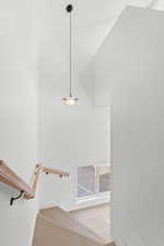 Staircase featuring wood finished floors and a high ceiling