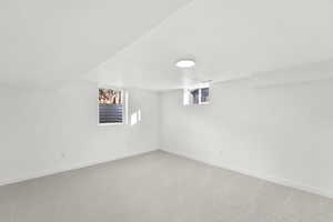 Basement featuring light colored carpet and a textured ceiling