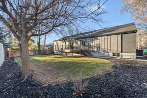 Rear view of house featuring a fenced backyard and board and batten siding