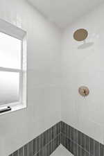 Full bath featuring a tile shower