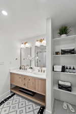 Bathroom with double vanity, a stall shower, a textured ceiling, and light tile patterned floors