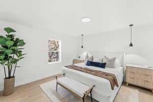 Bedroom with light wood-style flooring and baseboards