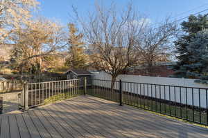 Wooden deck with a fenced backyard and a shed