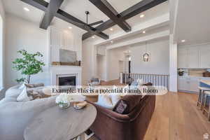 Living area featuring coffered ceiling, light wood finished floors, a ceiling fan, a large fireplace, and recessed lighting