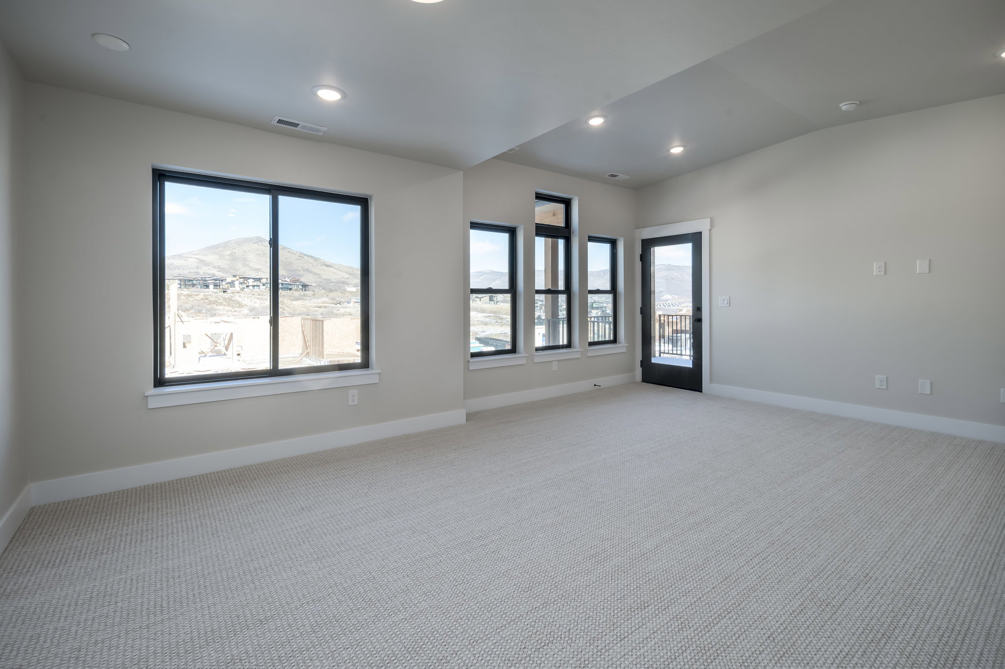 Spare room featuring light carpet, recessed lighting, a mountain view, healthy amount of natural light, and lofted ceiling