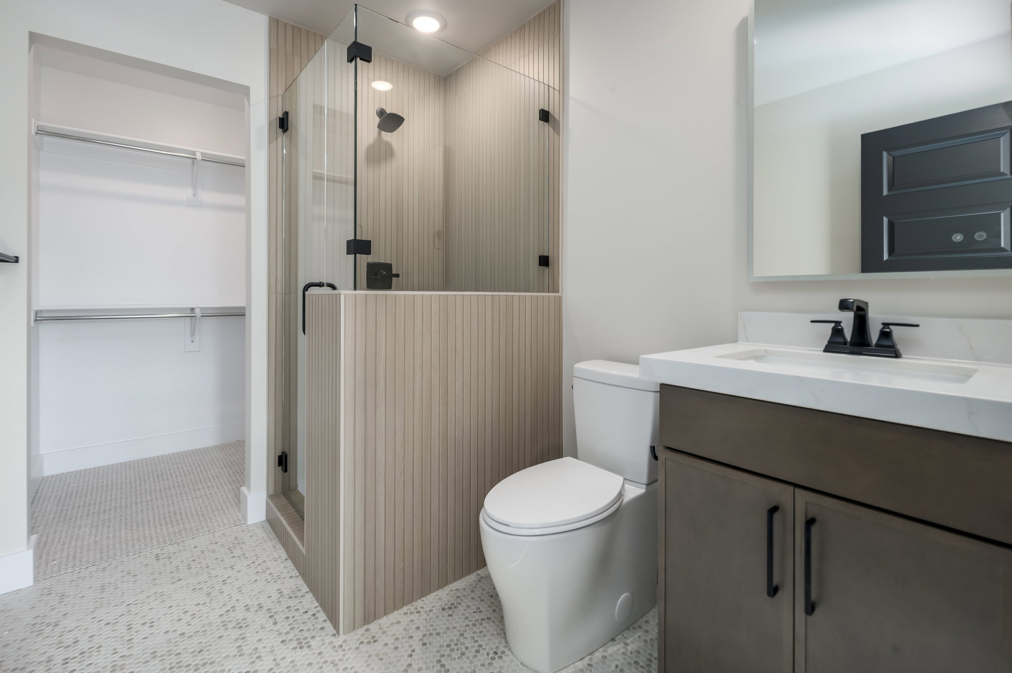 Bathroom featuring vanity, a stall shower, a walk in closet, light tile patterned flooring, and recessed lighting