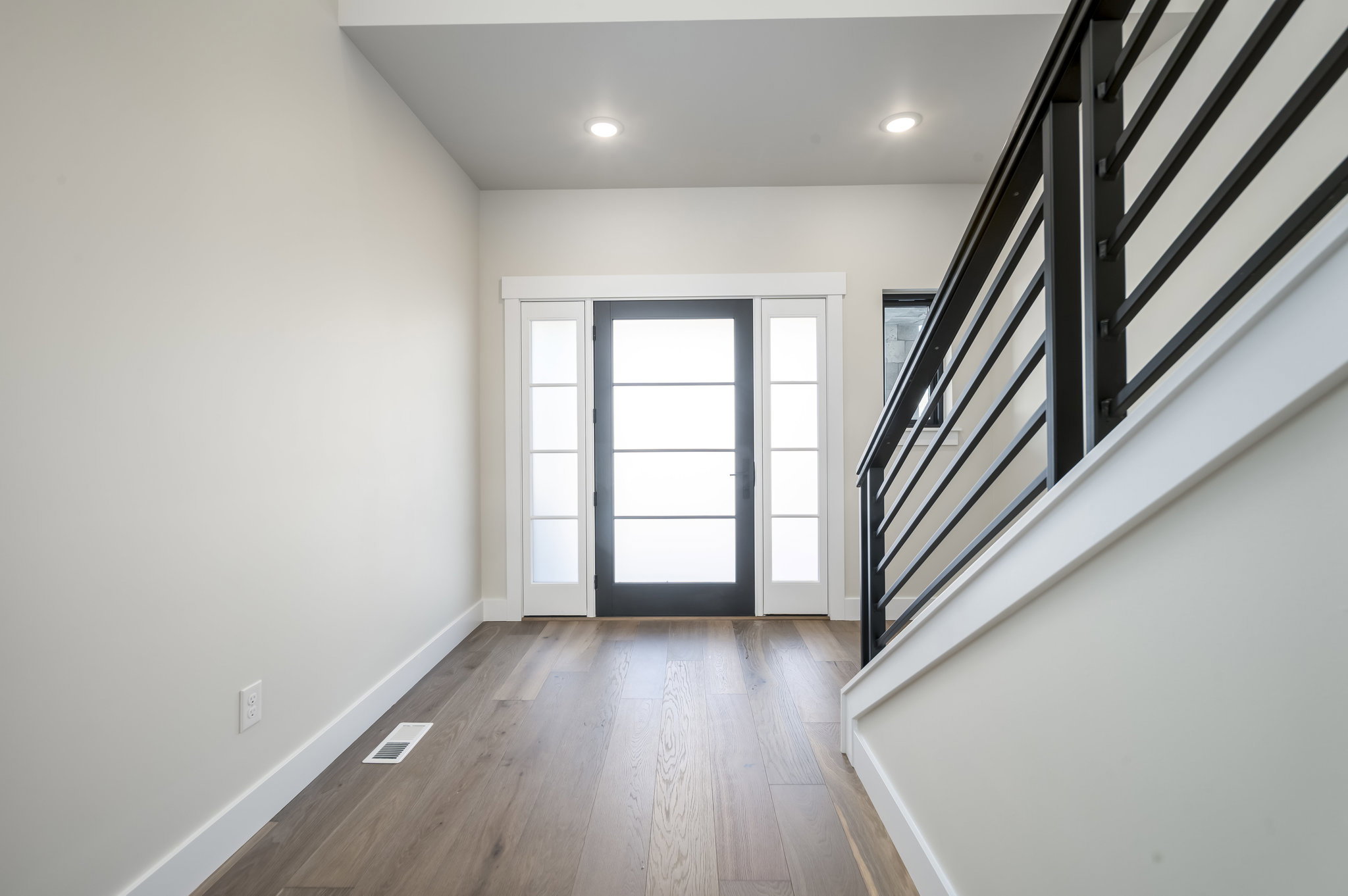 Foyer with dark wood finished floors and recessed lighting