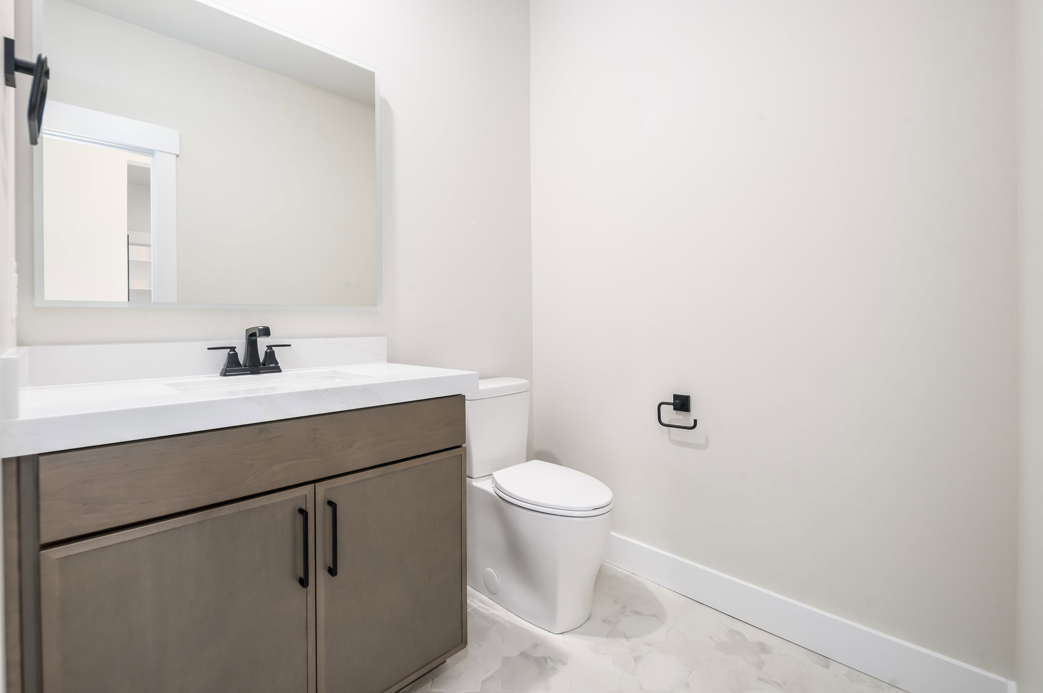 Half bath featuring vanity and light marble finish flooring