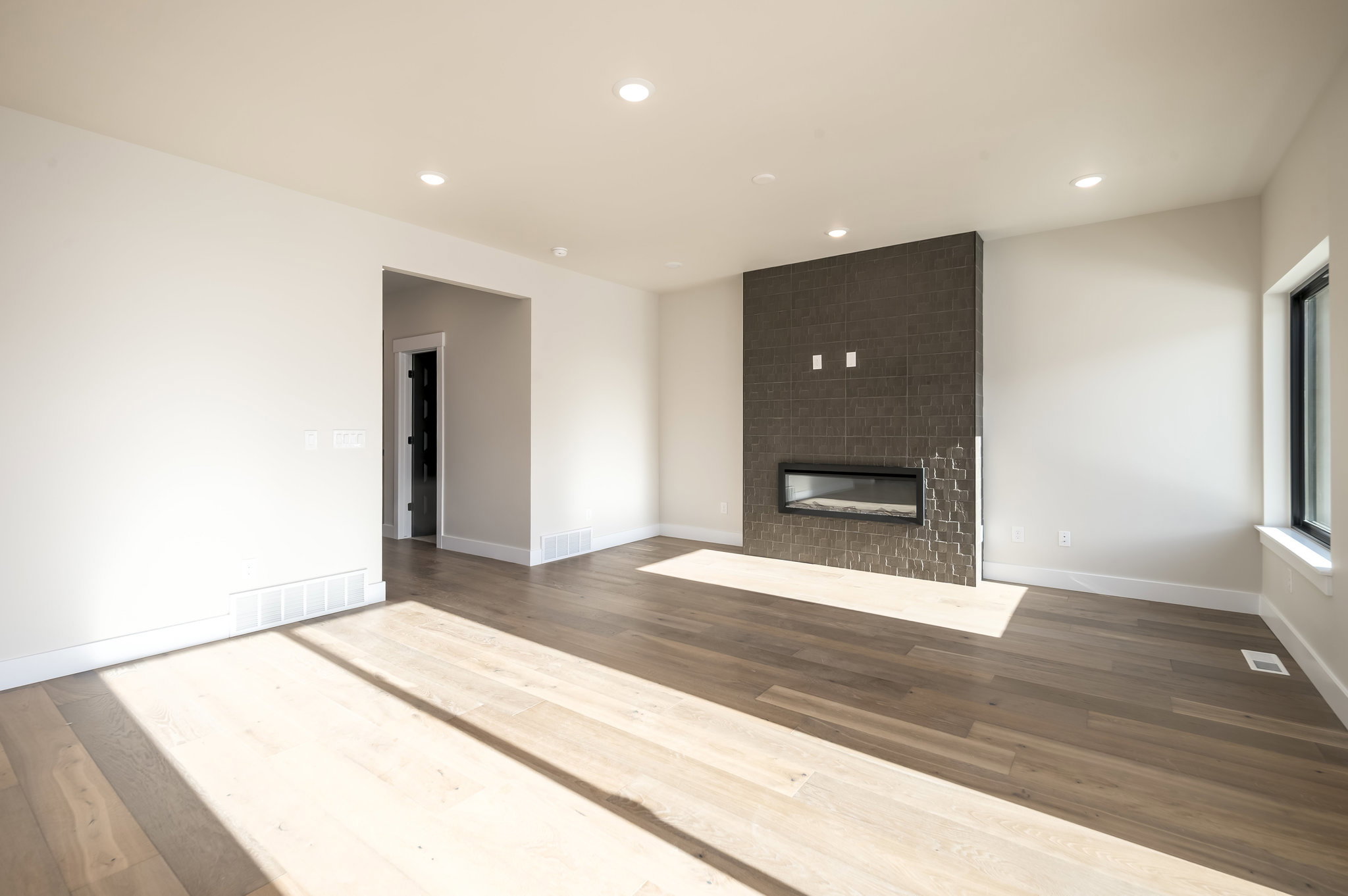 Unfurnished living room featuring recessed lighting, hardwood / wood-style flooring, and a large fireplace