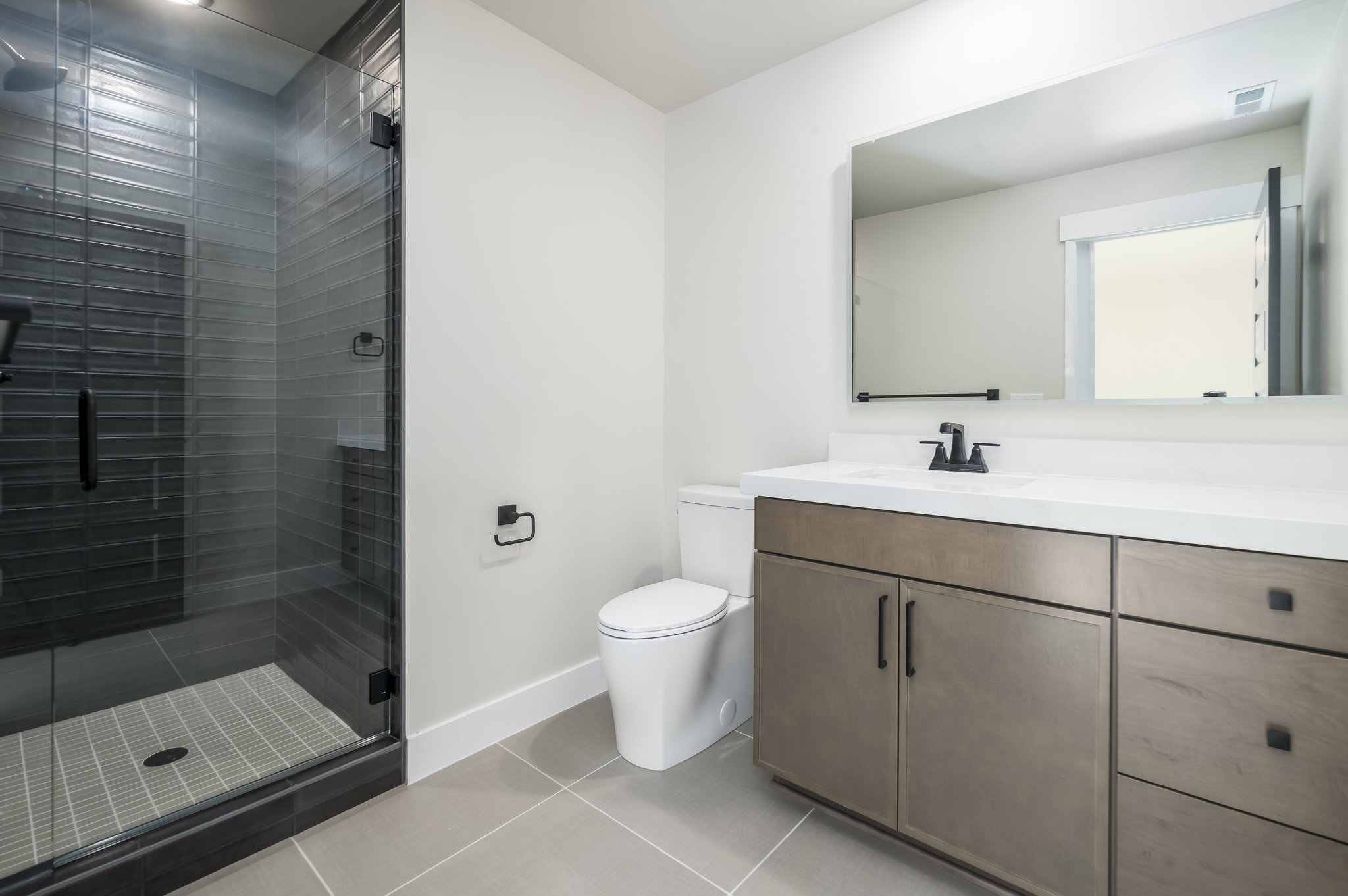 Full bathroom with vanity, a shower stall, and light tile patterned flooring