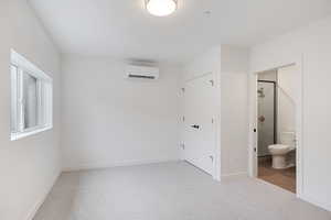 Unfurnished bedroom featuring light carpet, a closet, and ensuite bathroom