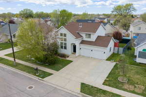 Traditional home featuring roof with shingles, concrete driveway, and a residential view