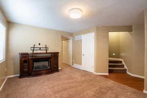 Carpeted living area with baseboards and a fireplace