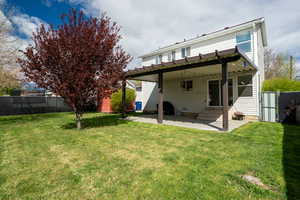 Back of house with a fenced backyard, a patio area, and a gate