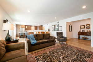 Living area with light wood-type flooring and recessed lighting