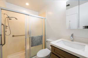 Full bath featuring vanity, a stall shower, and recessed lighting