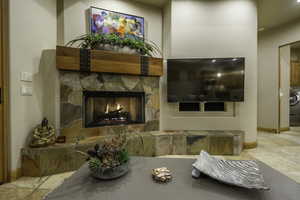 Living room with a fireplace, washer / clothes dryer, and light tile patterned flooring
