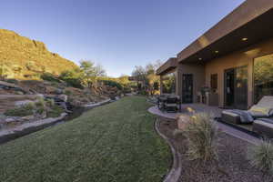 View of green lawn featuring a patio area and outdoor dining space