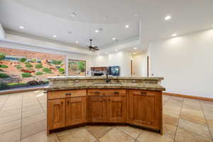 Central kitchen island featuring a built-in sink and stone countertop