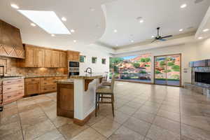 Spacious open concept living area featuring a kitchen with wood cabinetry, granite countertops, and built-in appliances