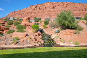 Manicured lawn fronting a xeriscaped rock garden with a multi-tiered waterfall feature