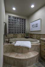 Full bath featuring vanity and a garden tub