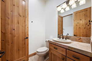 Bathroom vanity featuring a vessel sink, oil-rubbed bronze faucet, and a stone tile countertop with decorative accent tiles