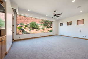 Expansive wall-to-wall carpeting in a neutral tone, complemented by a large picture window showcasing a rock landscape