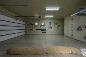 Garage featuring baseboards and a garage door opener