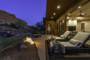 View of patio / terrace with a fire pit, outdoor dining area, and ceiling fan
