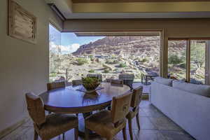 Dining area featuring healthy amount of natural light, stone tile flooring, and a mountain view
