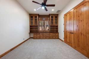 Built-in wood cabinetry with glass-front uppers and a desk area
