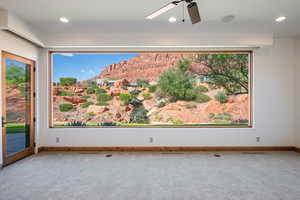 Expansive horizontal window framing a desert landscape with red rock formations and green foliage