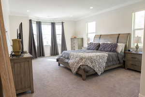 Carpeted bedroom with crown molding and recessed lighting
