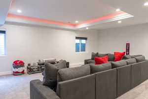 Carpeted living area with a tray ceiling and recessed lighting