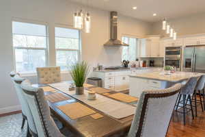 Kitchen featuring a breakfast bar area, white cabinetry, a kitchen island, light stone countertops, and stainless steel appliances