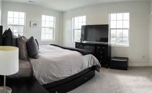 Bedroom featuring light carpet and baseboards