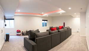 Cinema featuring a tray ceiling, recessed lighting, light colored carpet, and healthy amount of natural light